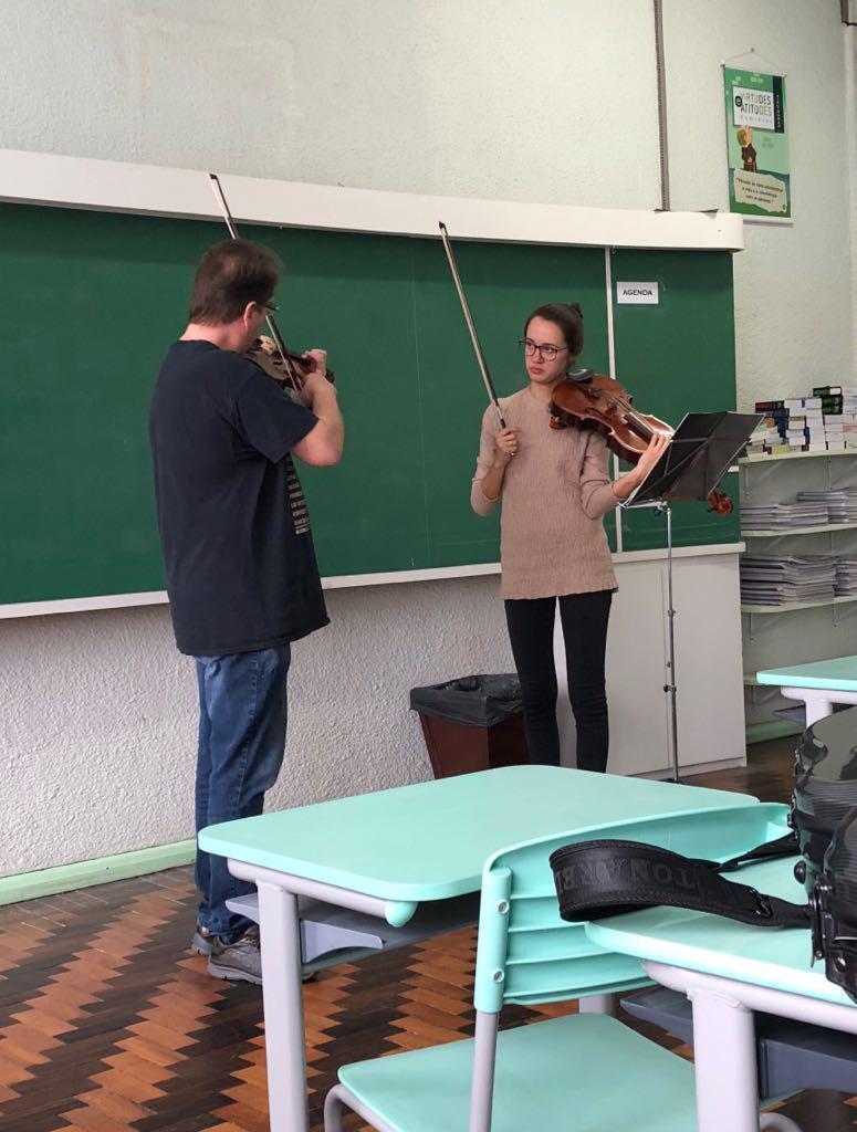 Jovem tendo aula de viola com professor