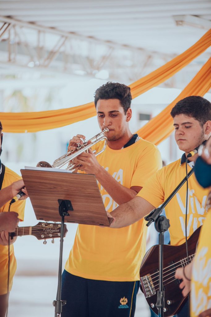 Alunos tocando guitarra, trompete e violão.