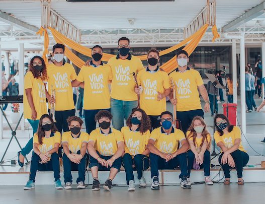 Imagem com alunos e funcionários usando camisetas amarelas com o título da campanha do Setembro Amarelo: Viva a Vida.