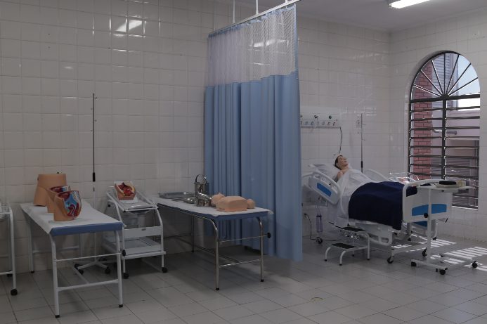 Camas e macas similares aos dos leitos hospitalares, com bonecos para aulas práticas.
